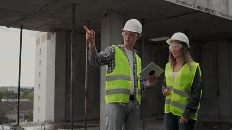 Engineers-or-architects-have-a-discussion-at-construction-site-looking-through-the-plan-of-construction.-contre-jour.-Engineers-or-architects-have-a-discussion